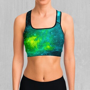 May include: A black sports bra with a galaxy print featuring shades of green and blue. The print has a nebula effect with a yellow center.