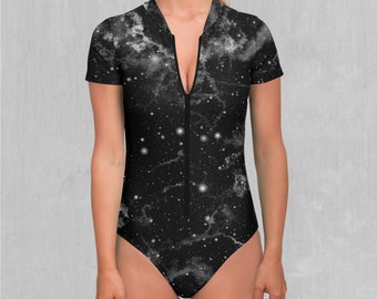 May include: A black and white short-sleeved swimsuit with a galaxy print. The one-piece swimsuit features a front zip and a high-cut leg. The fabric has a marbled effect with white star-like details.