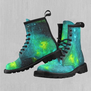 May include: A pair of black combat boots with a galaxy print featuring shades of blue and green. The boots have black laces and a thick black sole.