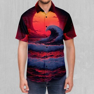 Puede incluir: Camisa de manga corta con un llamativo diseño de olas oceánicas. La camisa muestra un gran sol naranja que se pone sobre el mar, con olas en tonos azules y rojos. Tiene un cuello clásico y cierre de botones.