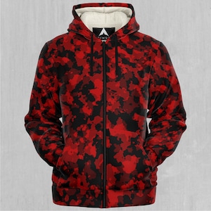 May include: A red and black camouflage-patterned zip-up hoodie with a white fleece-lined hood. The hoodie has a full-length zipper and two front pockets. The brand logo is visible on the hood.