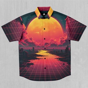 Puede incluir: Una camisa de manga corta con botones y un diseño retrofuturista. La camisa presenta un gran sol naranja, una ciudad y un patrón de cuadrícula en tonos rojos, naranjas y negros.