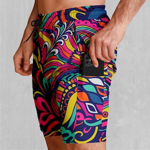 Puede incluir: Pantalones cortos deportivos de patrón colorido con un bolsillo con cremallera en el lateral. El bolsillo tiene un teléfono inteligente negro en su interior.
