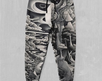 May include: Black and white sweatpants featuring a graphic print of a fantastical landscape with a tower, trees, and clouds.