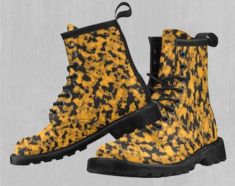Pode incluir: Um par de botas de couro preto com estampa de camuflagem amarela e preta. As botas têm cadarços e uma sola grossa.