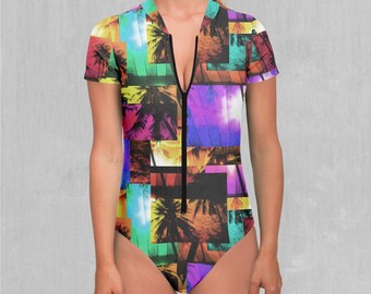 May include: A black one-piece swimsuit with a colourful geometric pattern of palm trees and a zip down the front.