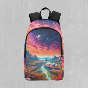 May include: A black backpack with a colourful, abstract design featuring a landscape with a river, mountains, and planets. The design has shades of pink, orange, blue, and purple.
