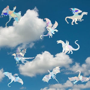 May include: Eight iridescent holographic dragon cutouts against a blue sky with white clouds. The dragons are in various poses, some flying, some with wings spread, and some with wings folded.