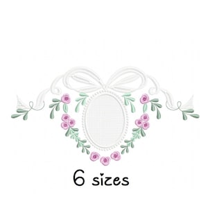 Könnte beinhalten: Ein weißes Stickmuster mit einem Blumenkranz mit rosa Blüten und grünen Blättern, die einen weißen ovalen Rahmen umgeben. Das Design enthält eine weiße Schleife und den Text "6 Größen".