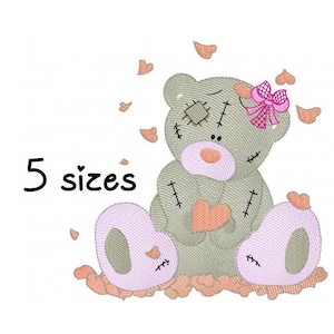 May include: A gray patchwork teddy bear with pink accents sits on a bed of pink hearts. The bear is holding a pink heart in its paws. The text "5 sizes" is visible in the image.