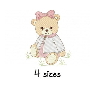 Pode incluir: Desenho bordado de um urso de peluche marrom vestindo uma jaqueta branca e um laço rosa. O urso está sentado em um pedaço de grama verde. O texto "4 tamanhos" está abaixo do urso.