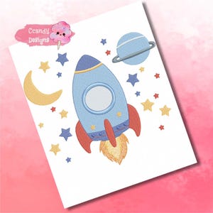 以下が含まれることがあります： 青いロケットに赤と黄色のアクセントが施された刺繍のデザイン。黄色の三日月、リングのある青い惑星、そしてたくさんの星と共に宇宙を飛んでいます。