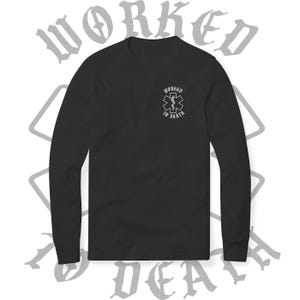 May include: Black long-sleeve shirt with a small white graphic on the chest featuring an emblem and the words "WORKED TO DEATH." The shirt has a crew neck and long sleeves. The words "WORKED TO DEATH" are also printed in a gothic font in the background.