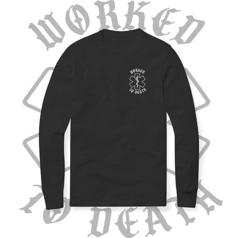 May include: Black long-sleeve shirt with a small white graphic on the chest featuring an emblem and the words "WORKED TO DEATH." The shirt has a crew neck and long sleeves. The words "WORKED TO DEATH" are also printed in a gothic font in the background.