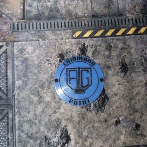Peut inclure: Un jeton bleu "Command Point" avec les lettres "AG" à l'intérieur d'un cercle. Le texte "COMMAND POINT" est imprimé sur le bord. Le jeton est posé sur une surface grise et noire.