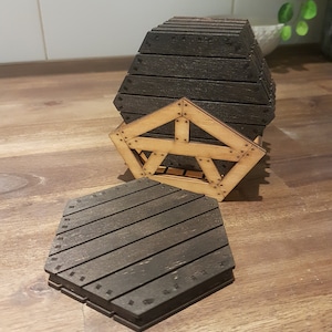 May include: A set of hexagonal wooden coasters with a dark brown finish. The coasters are stacked in a wooden holder with a geometric design.