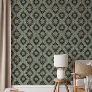 May include: A room with a patterned wallpaper featuring a repeating geometric design in shades of green and gold. A lamp sits on a wooden stool next to a couch with a throw pillow.