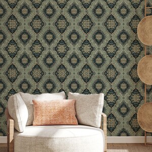May include: A round white chair with a light orange pillow sits in front of a wall covered in a dark green and gold patterned wallpaper.