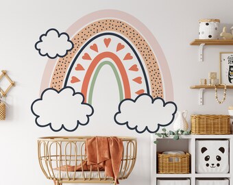 May include: A colorful rainbow wall decal with pink, orange, red, green, and blue colors. The rainbow has a dotted pattern and hearts along the arch. There are three white clouds with black outlines.