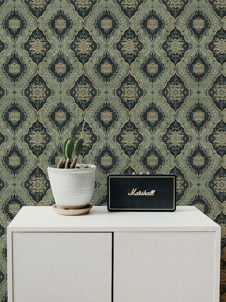May include: A white cabinet with two doors against a backdrop of green and gold patterned wallpaper. A small potted cactus and a black Marshall speaker are on top of the cabinet.