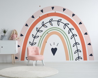 May include: A pink upholstered chair sits in front of a white wall with a rainbow mural featuring a leafy vine, hearts, and gold stars.