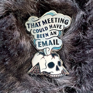 May include: Gold-colored enamel pin with a white skull and a speech bubble that says "That meeting could have been an email".