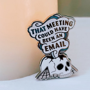 May include: A silver enamel pin with a skull and a speech bubble that says "That meeting could have been an email".