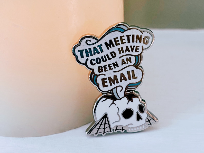 May include: A silver enamel pin with a skull and a speech bubble that says "That meeting could have been an email".