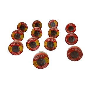 May include: A collection of vintage Fustat dual-element fuses. The fuses are cylindrical with red and yellow labels. Each fuse is marked with "Fustat", "S 20", and "Dual Element Type Fuse".