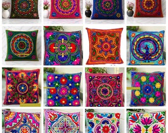 Puede incluir: Una colección de cojines cuadrados con intrincados diseños bordados. Cada cojín presenta un patrón único con colores vibrantes como rojo, azul, verde y rosa. Los diseños incluyen motivos florales y geométricos, agregando un toque decorativo a cualquier espacio.
