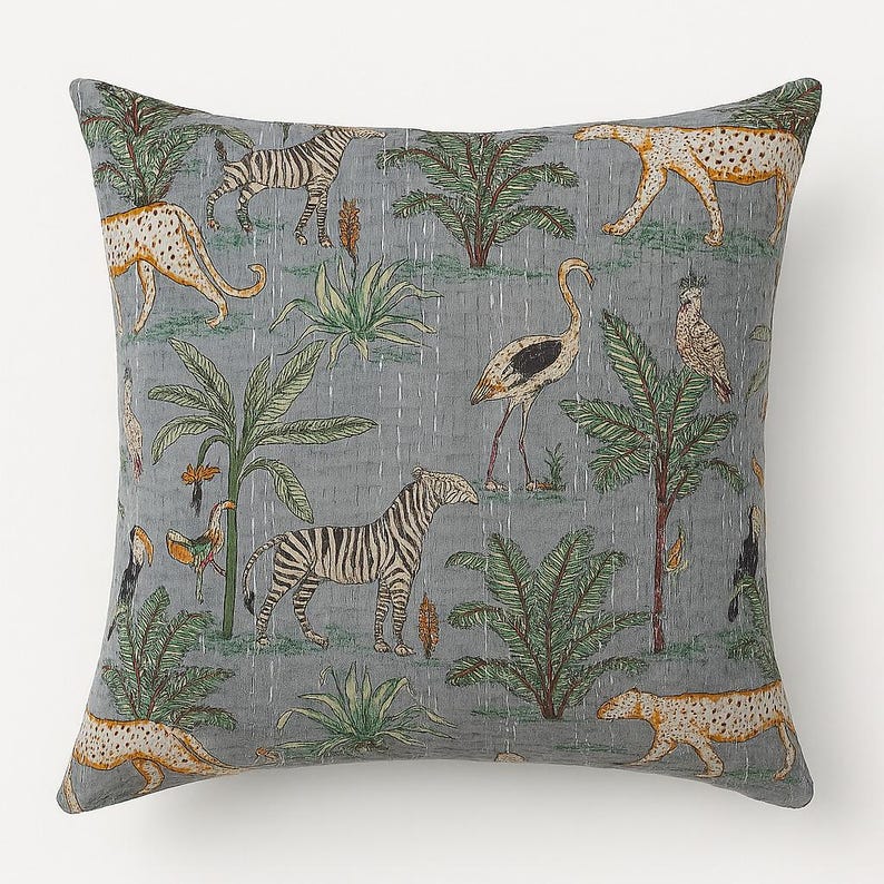 May include: Square throw pillow with a gray background featuring a jungle scene. The design includes zebras, leopards, birds, and palm trees in shades of green, tan, and black. The pillow has a quilted texture.