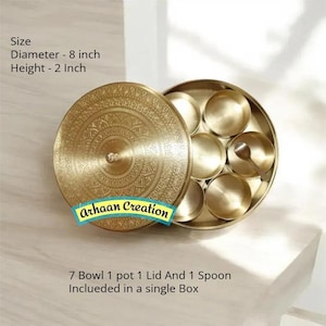 Op de afbeelding: Een ronde kruidendoos van messing met een ingewikkeld gegraveerd deksel, met zeven kleine schaaltjes en een lepel. De container heeft een diameter van 20,32 cm en een hoogte van 5,08 cm. De tekst Arhaan Creation is zichtbaar op het messing deksel.