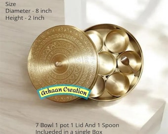 May include: A round brass spice box with an intricate engraved lid, containing seven small bowls and one spoon. The container measures 20.32 cm in diameter and 5.08 cm in height. The text Arhaan Creation is visible on the lid of the brass container.