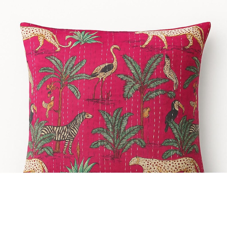 May include: A square magenta pillow with a jungle-themed print. The design features zebras, leopards, toucans, and palm trees. The pillow has a quilted texture with white stitching.