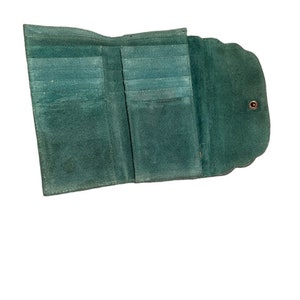 May include: A green leather wallet with multiple card slots and a fold-over closure.
