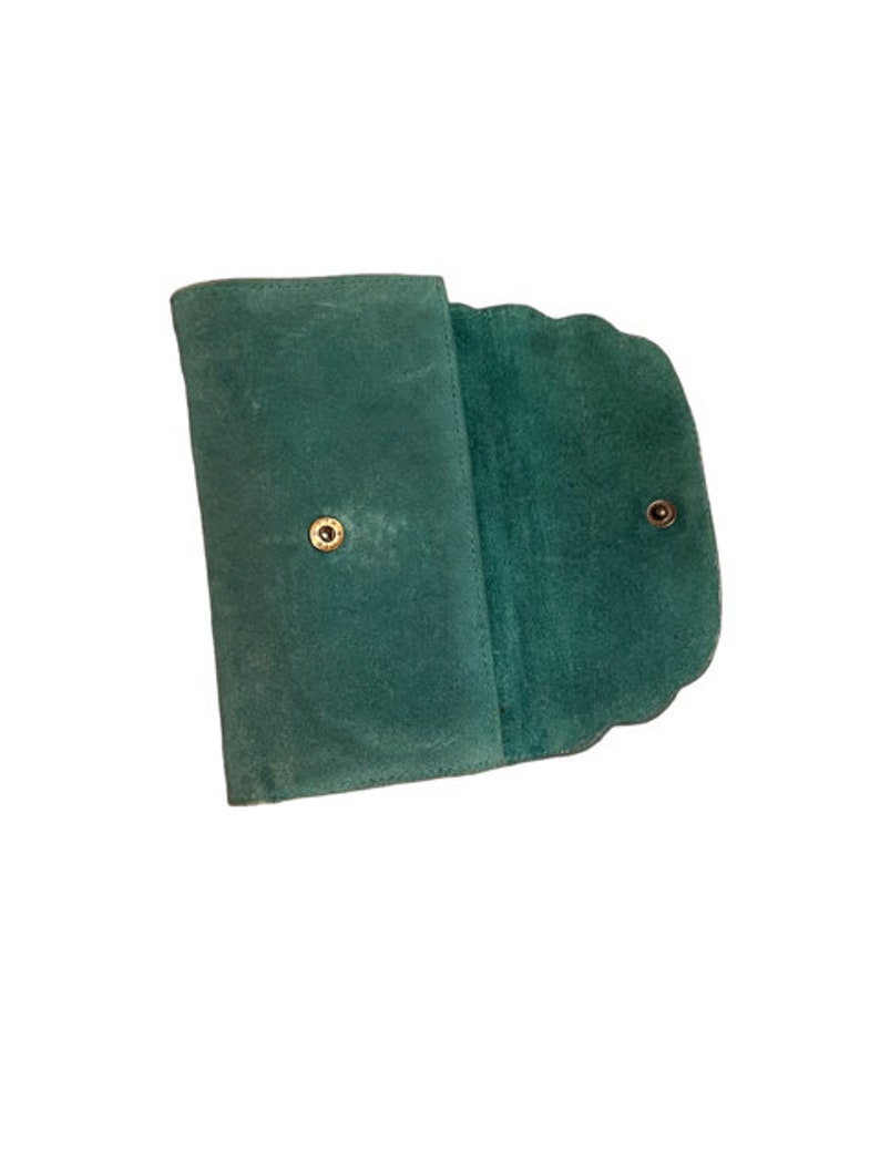 May include: A teal green suede wallet with a scalloped edge and two gold snaps.
