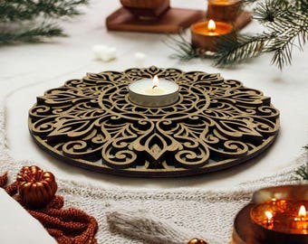 May include: A wooden candle holder with a intricate mandala design. The holder has a small, round opening in the center for a tea light candle. The candle holder is surrounded by a white knitted surface and other decorative items.