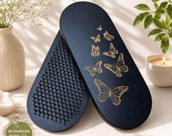 May include: Two oval-shaped wooden boards with a dark navy finish. One board features a dense grid of small, upright black metal nails on its surface. The other board displays a series of gold-colored butterfly illustrations in varying sizes.