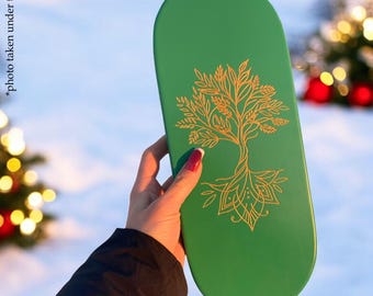 May include: An oval green wooden tray featuring a gold-colored line art illustration of a tree with intricate roots and branches. The text "photo taken under the sun" is printed vertically along the left side of the green surface.