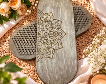 May include: Two oval-shaped wooden boards featuring a gray finish and a laser-engraved mandala pattern on the top surface. Each board is embedded with numerous sharp metal nails arranged in a grid, designed for standing or foot pressure exercises.