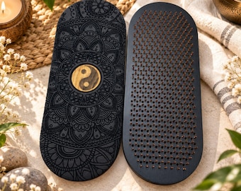 May include: Two oval-shaped wooden boards with a black finish. One board features an intricate engraved mandala pattern with a central yin-yang symbol. The other board is covered in a dense grid of sharp, upright metal nails.