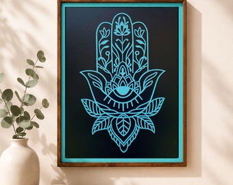 May include: A framed wall art piece featuring a bright cyan Hamsa hand symbol with intricate floral and eye motifs centred on a solid black background. The artwork is enclosed in a dark brown wooden frame with a thin cyan inner border.
