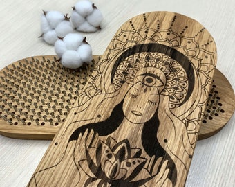 May include: Two oval wooden boards featuring a laser-engraved illustration of a person with a third eye and a lotus flower. The boards are embedded with numerous small, sharp metal nails arranged in a grid pattern, designed for standing or foot use.