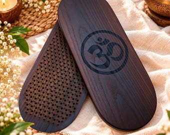 May include: A pair of oval-shaped dark brown wooden boards featuring a bed of numerous small metal nails on one side and a laser-engraved Om symbol on the other. The boards have a smooth, polished finish with visible wood grain patterns throughout.