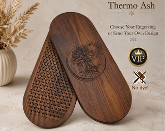 May include: Two oval-shaped Premium Thermo Ash wood boards with a dark brown finish. One board features a laser-engraved tree design, while the other displays a dense grid of metal nails. Text includes Premium Thermo Ash, Choose Your Engraving, and No dye!