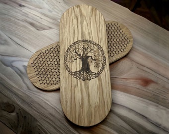 May include: Two oval-shaped wooden boards with a light brown grain pattern. The top board features a dark brown laser-engraved tree of life design enclosed in a circular Celtic knot border. Both boards have a grid of small, dark metal nails.