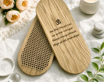 May include: Two oval wooden boards with a light oak grain finish. One board features a dense grid of small metal nails, while the other displays the Om symbol and the Sanskrit Gayatri Mantra text in black ink, centered on the smooth wood surface.