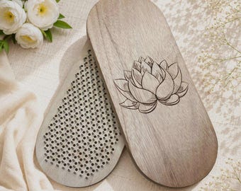 May include: Two oval wooden boards with a light brown grain. One board features a laser-engraved lotus flower design on its smooth surface. The other board displays a dense grid of numerous small, evenly spaced metal nails protruding upward.