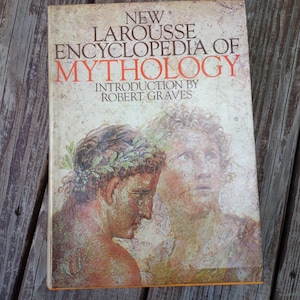 May include: A vintage hardcover book titled "New Larousse Encyclopedia of Mythology" with an introduction by Robert Graves. The cover features a faded illustration of two classical figures with laurel wreaths, in shades of orange, brown, and beige.