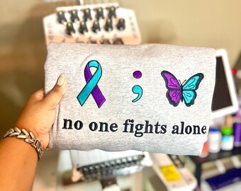 Pull de sensibilisation à la santé mentale « Personne ne combat seul » | Ruban turquoise et violet | Broderie papillon point-virgule